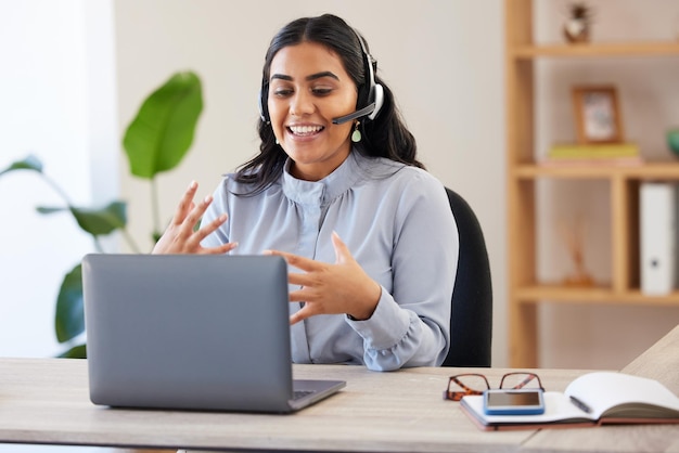 Video call laptop and seminar with a business indian woman meeting online while sitting in her office at work Remote work headset and communication with a female employee talking in a webinar