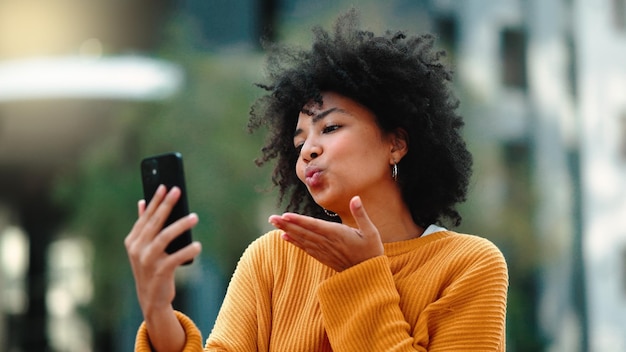 Video call phone and black woman in city talking online travel update and 5g communication or funny chat Laughing gen z person or student on cellphone mobile and live streaming for urban outdoor