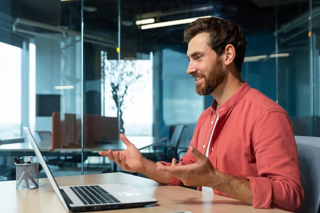 Video call of successful and cheerful smiling businessman man talking remotely using laptop while