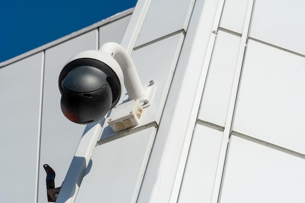 Video surveillance cameras installed on the white wall at the entrance to the supermarket Security and antitheft systems Protection of personal property and protection of private territory