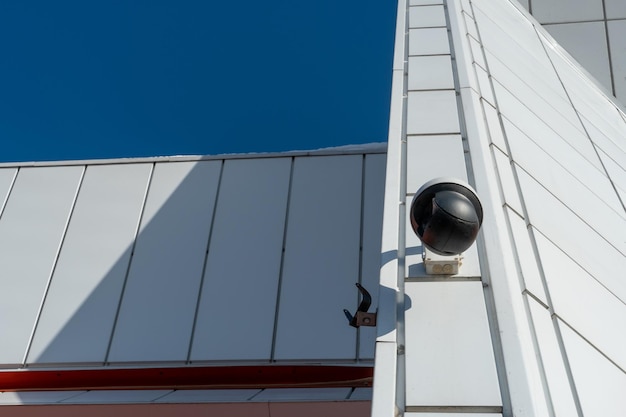 Video surveillance cameras installed on the white wall at the entrance to the supermarket Security and antitheft systems Protection of personal property and protection of private territory