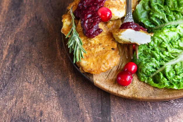 Viennese chicken schnitzel served with cranberry sauce and green salad