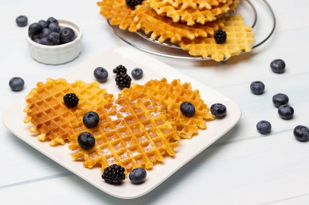 Viennese waffles and berries on a white plate Blueberries in a bowl