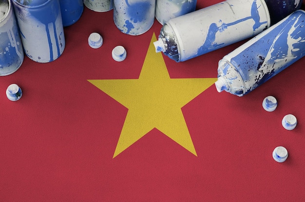 Vietnam flag and few used aerosol spray cans for graffiti painting Street art culture concept