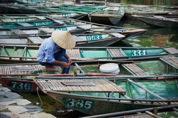 Vietnamese man with hat working in a boat