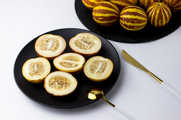 Vietnamese melon close up Whole and cut gourmet miniature tropical fruit and knife Selective focus