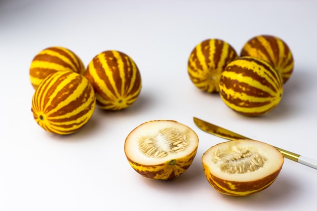 Vietnamese melon close up Whole and cut gourmet miniature tropical fruit and knife Selective focus