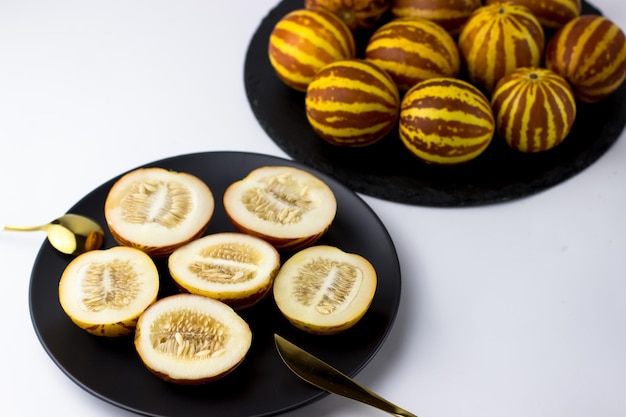 Vietnamese melon close up Whole and cut gourmet miniature tropical fruit and knife Selective focus