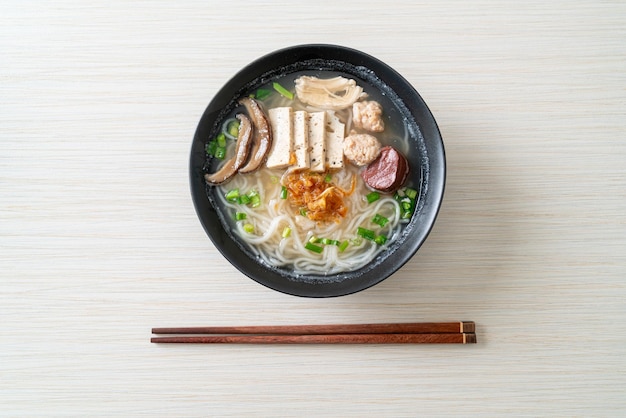 Vietnamese Rice Noodles Soup with Vietnamese Sausage served vegetables and crispy onion