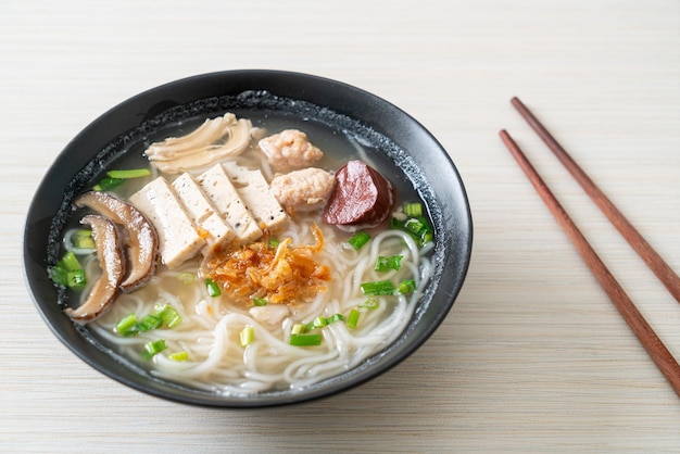 Vietnamese Rice Noodles Soup with Vietnamese Sausage served vegetables and crispy onion