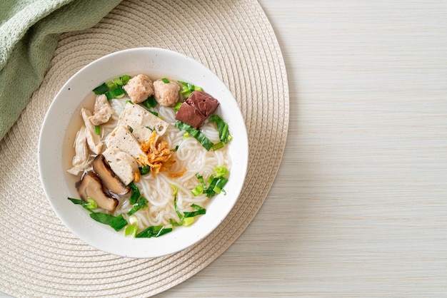 Vietnamese Rice Noodles Soup with Vietnamese Sausage served vegetables and crispy onion