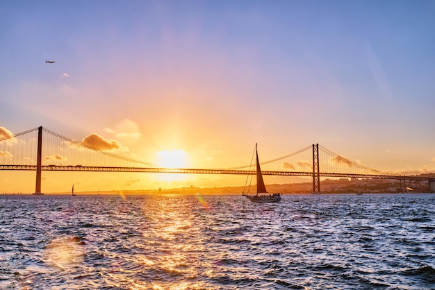 View of 25 de Abril Bridge over Tagus river on sunset Lisbon Portugal