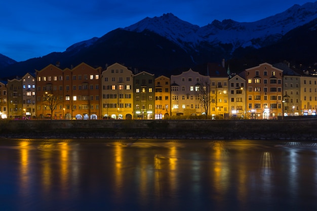 View across the river of colourful buildings of Innsbruck, Austria at night 