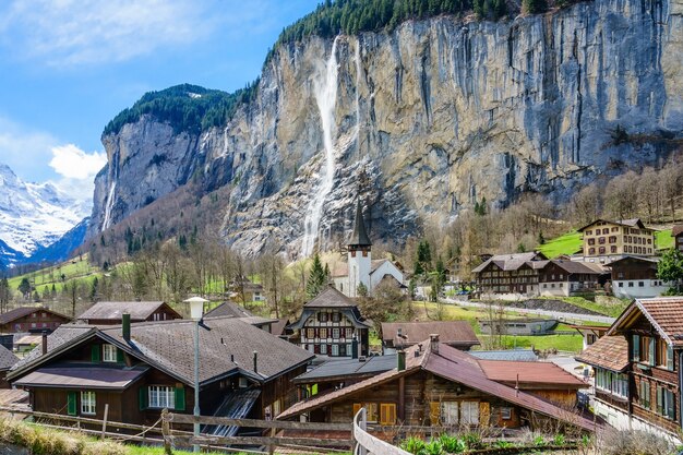 view of amazing alpine village with famous church and Staubbach waterfall