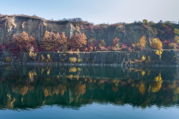 View of the artificial lake in a flooded part of a granite quarry lined with stone, clear water