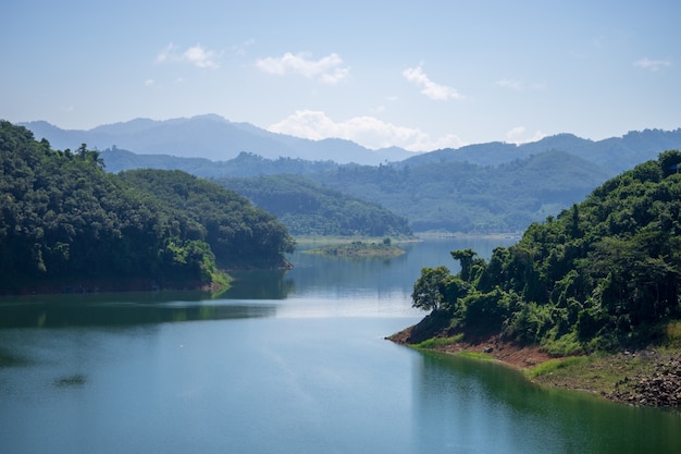 View of Bang Lang Dam water between two mountains and clear blue sky.