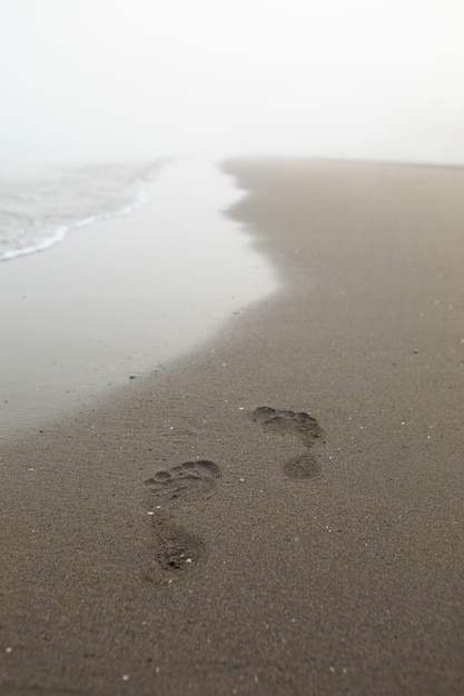 Photo view of beach sand in summertime with footprints