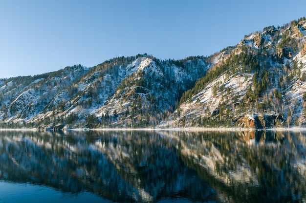 View of a beautiful river valley surrounded by mountains with snow at sunset