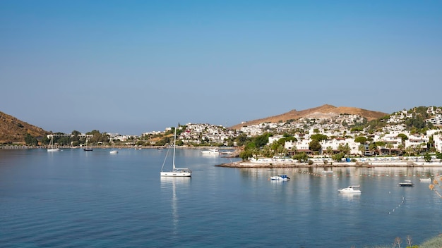 View of Bodrum Beach Aegean sea traditional white houses flowers marina sailing boats yachts in Bodrum town Turkey