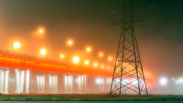 View of the bridge in the fog with beautiful illumination Beautiful misty cityscape