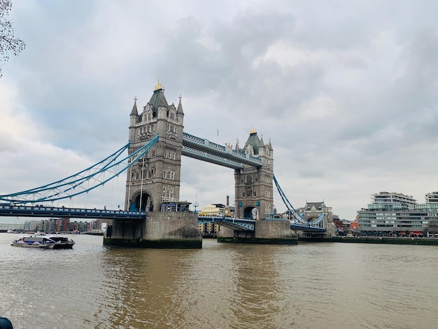 Photo view of bridge over river against cloudy sky