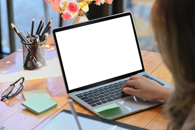 View over businesswoman shoulder working with computer laptop