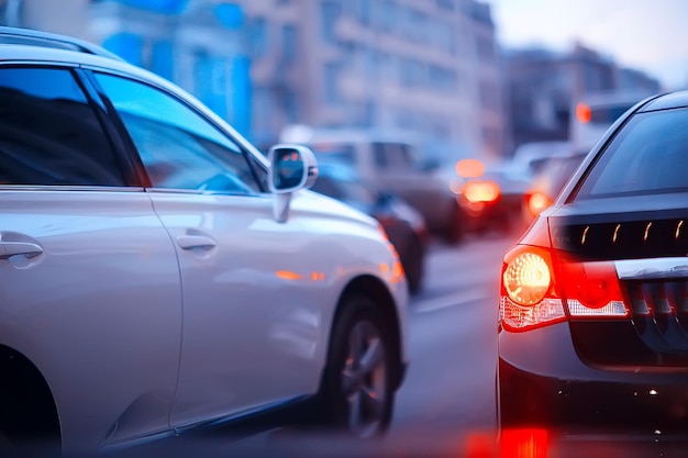 view of car in  traffic jam / rear view of the landscape from window in car, road with cars, lights and the legs of the cars  night view