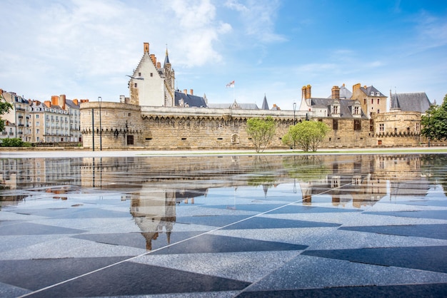 View on the castle of Dukes of Brittany with water mirror fountain in Nantes city in France