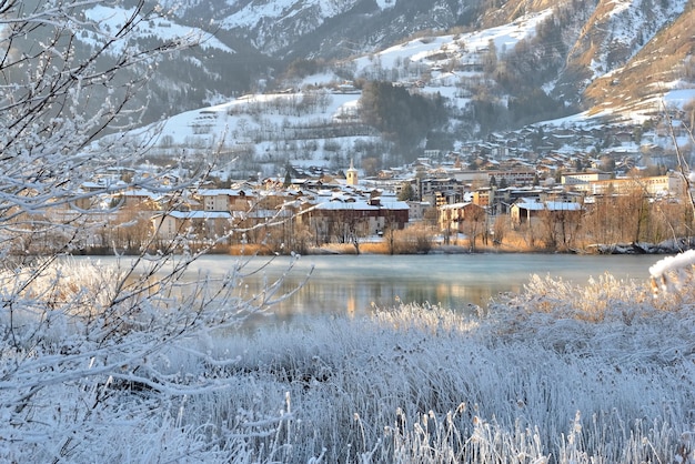 View of a city of Savoy, Bourg Saint Maurice,  on the banks of a river with frozen trees and plants