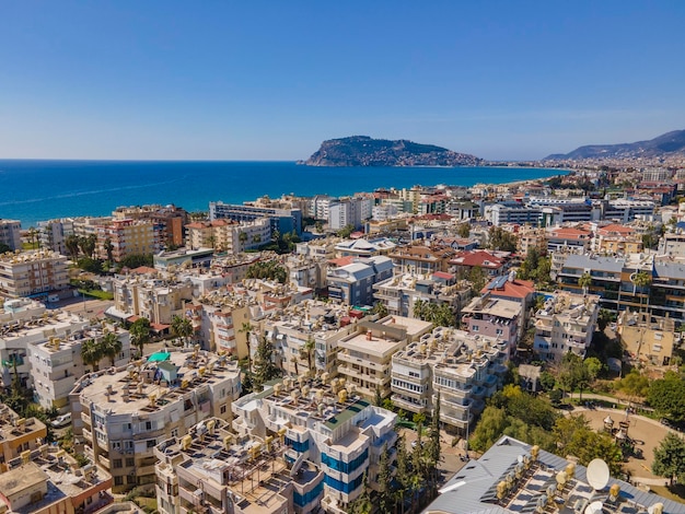 A view of a city with a blue sky and the sea in the background.