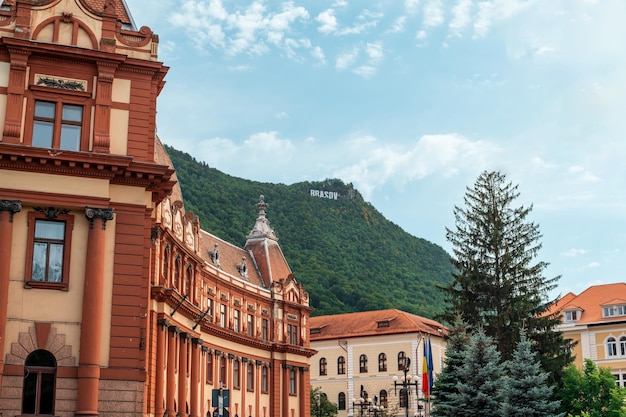 View of classic buildings in old Brasov centre Romania Hill with greenery and city sign on the background