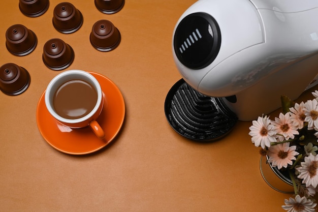 Above view coffee machine and coffee capsules on brown leather