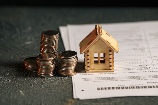 View Of coin stack with house model on green