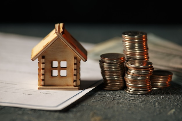 View Of coin stack with house model on green