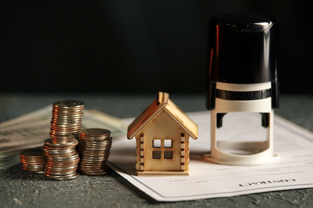 View Of coin stack with house model on green