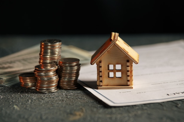 View Of coin stack with house model on green