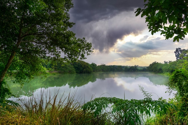 View of Colorful dramatic sky sunset or sunrise with clouds background on Water River in Forest, Sky with cloud in nature and travel concept.