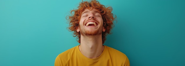 Photo view of a curlyhaired caucasian man in a mustardcolored tshirt bursting into laughter as he reacts to a hilarious story within