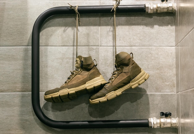 View of drying shoes hanging from laces Militarystyle sand boots