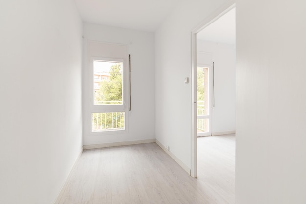 View of an empty white bright room with window without furniture after painting and renovation with