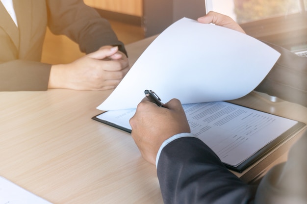 View of a Examiner reading a resume during a job interview