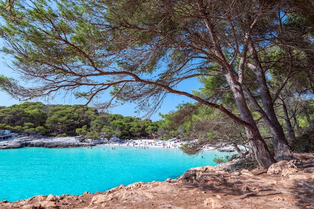 View of the famous beach Cala Turqueta. (Focus on foreground, people on the beach in blur). Menorca, Balearic islands, Spain