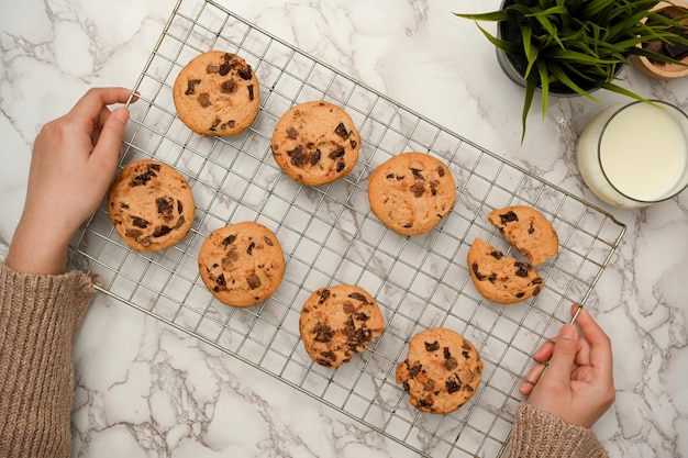 Above view Female putting freshly baked cookies on the table Homemade chocolate chip cookies