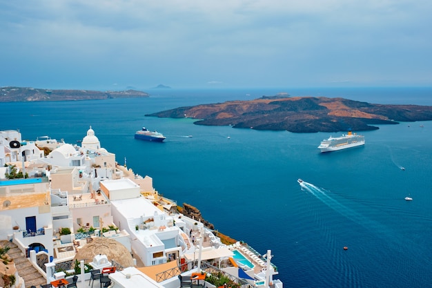 View of fira town on santorini island with cruise ships in sea