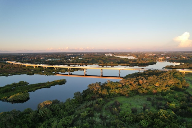 View of Fort Hamer Bridge and trees under the blue sky reflected in the water