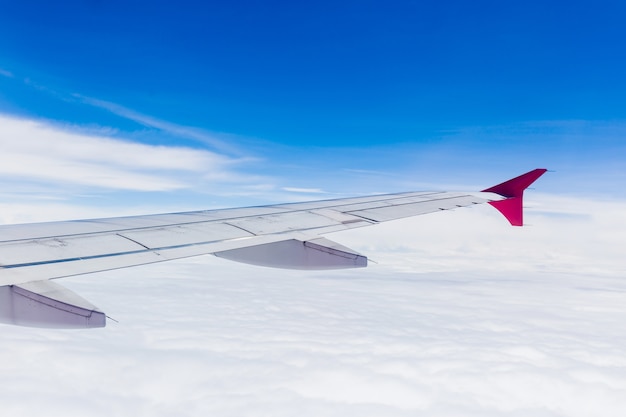 View from airplane window. Wing of an airplane flying above the clouds