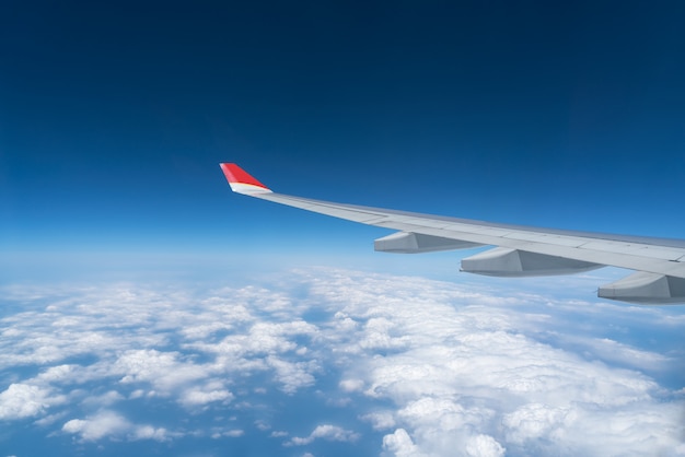 View from airplane window with blue sky and white clouds