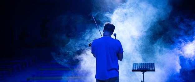 View from the back of a man playing the violin on stage