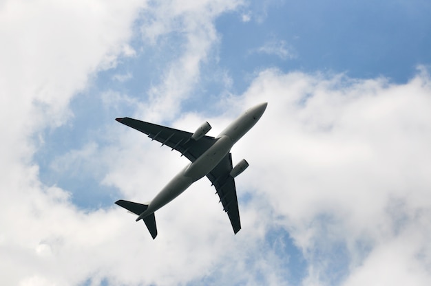  View from below commercial jet airplane flighting on sunny day cloudy  sky 