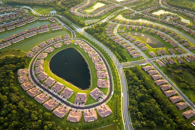 View from above of densely built residential houses near retention ponds in closed living clubs in south Florida American dream homes as example of real estate development in US suburbs